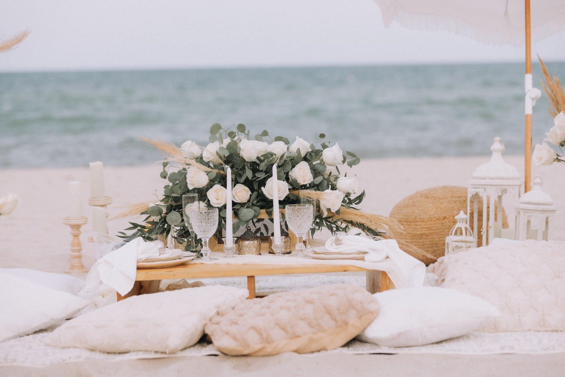 Low lounge picnic with cushions and flowers on the beach
