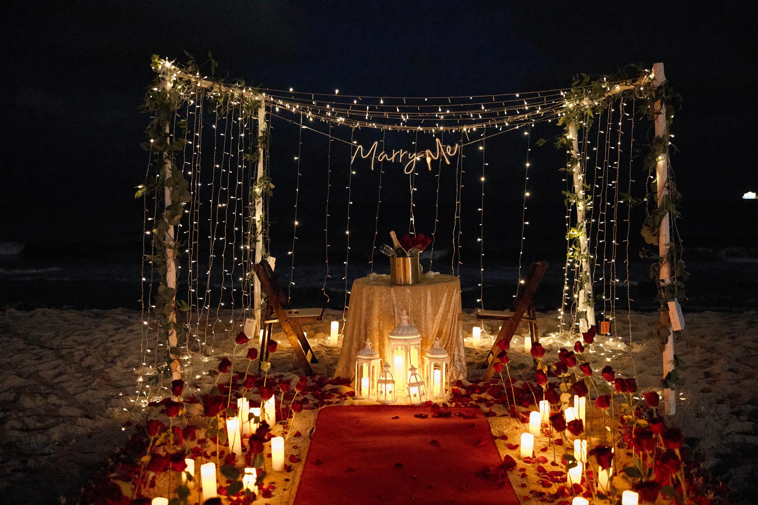 Candlelit aisle leading to a floral ceremony setup