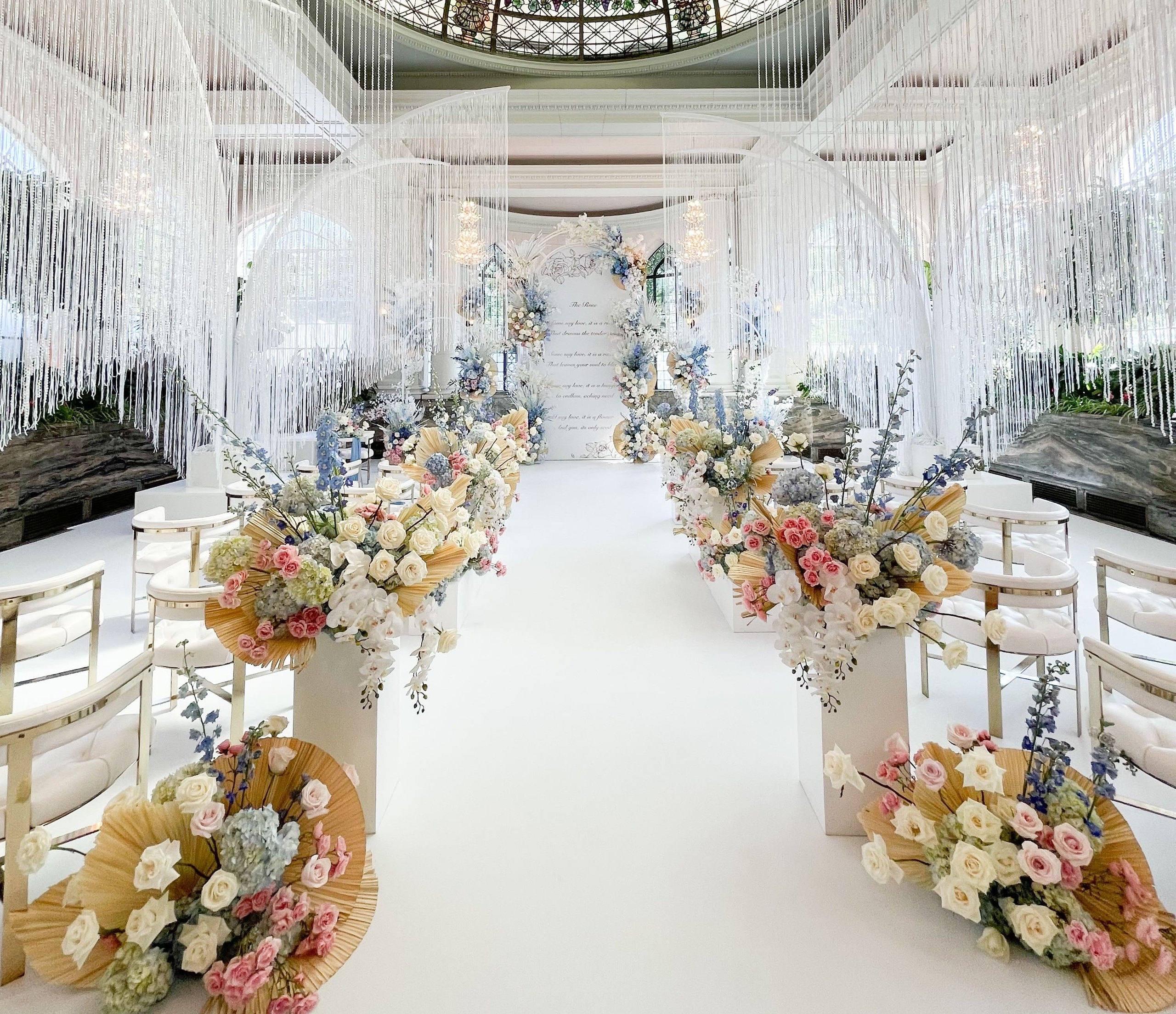 White aisle with crystal strands and soft floral arrangements