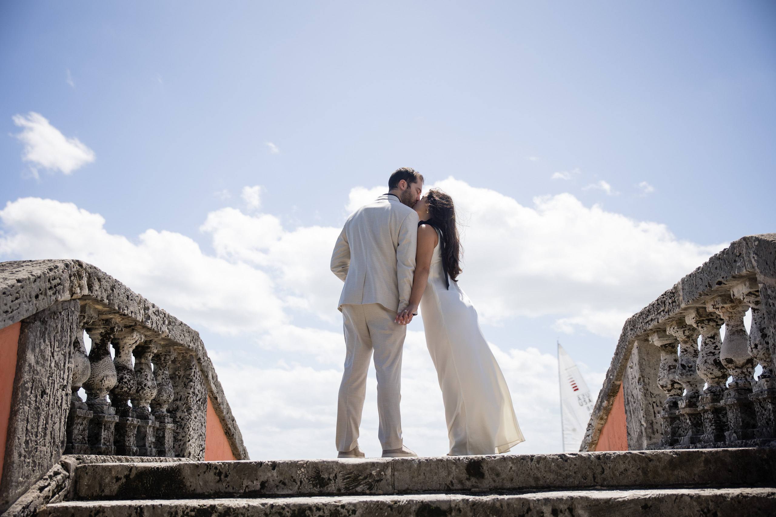 Couple walking across a stone bridge in a garden