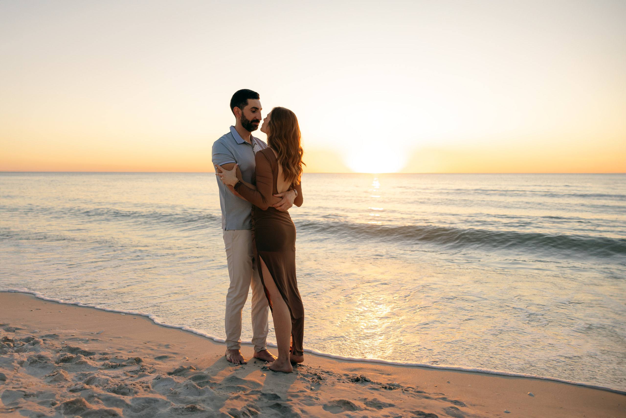 Couple embracing on the beach in warm sunset light