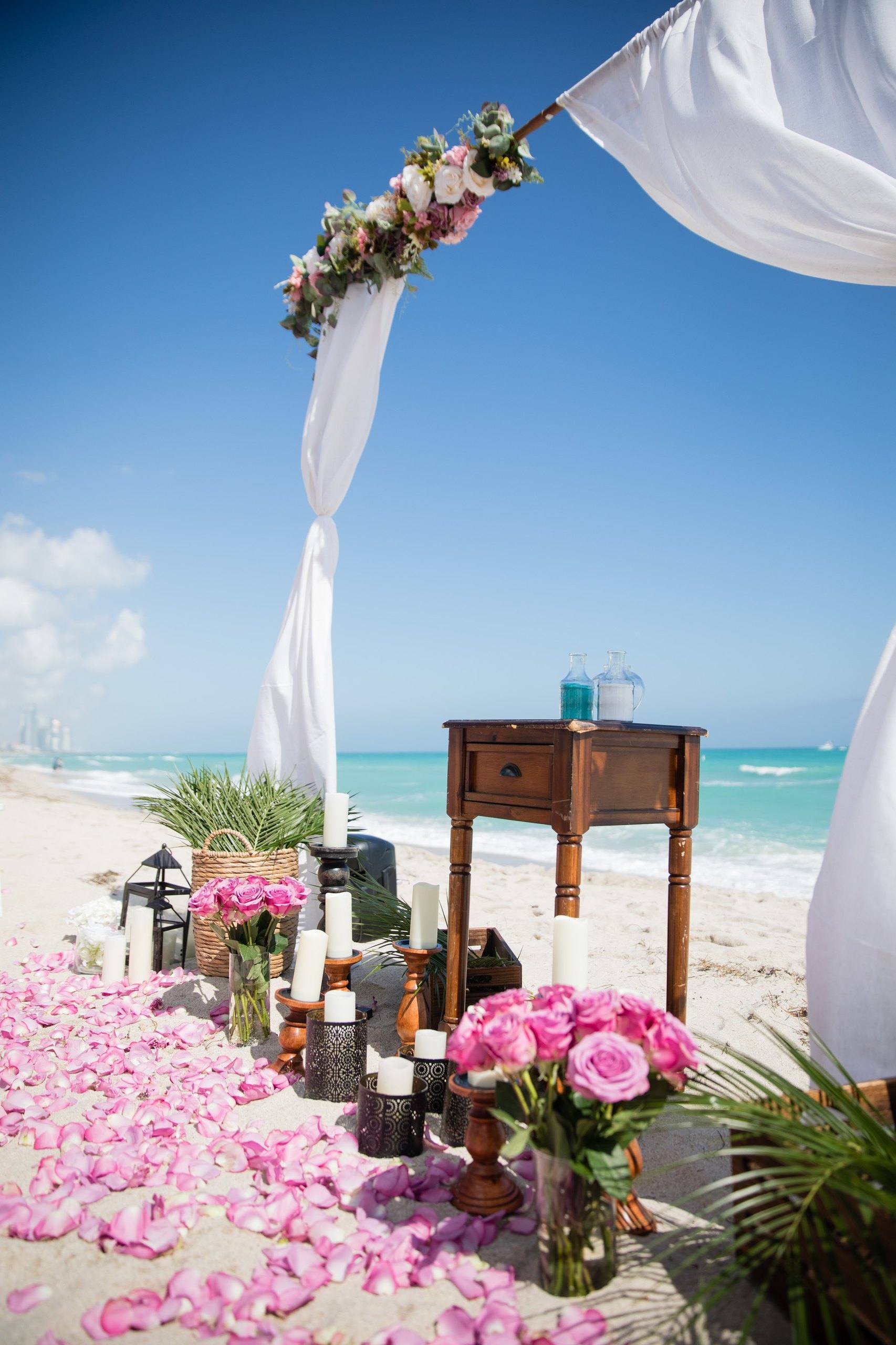 Two post arch with pink flowers on the beach