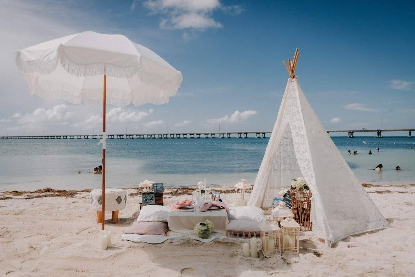 Picnic under a white shade with rugs and cushions