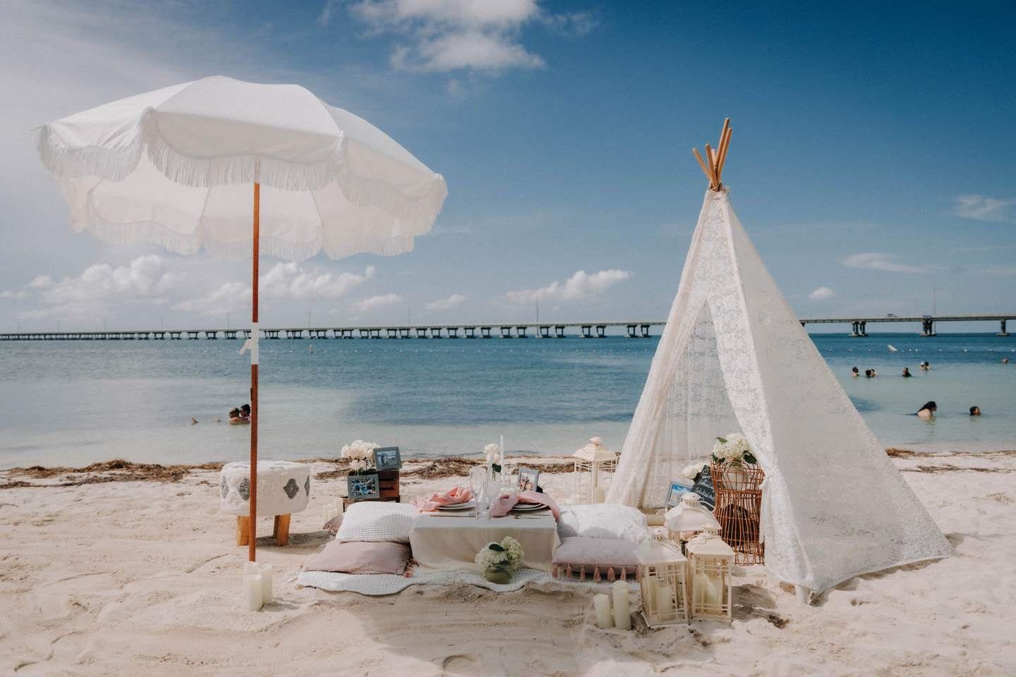 Picnic under a white shade with rugs and cushions