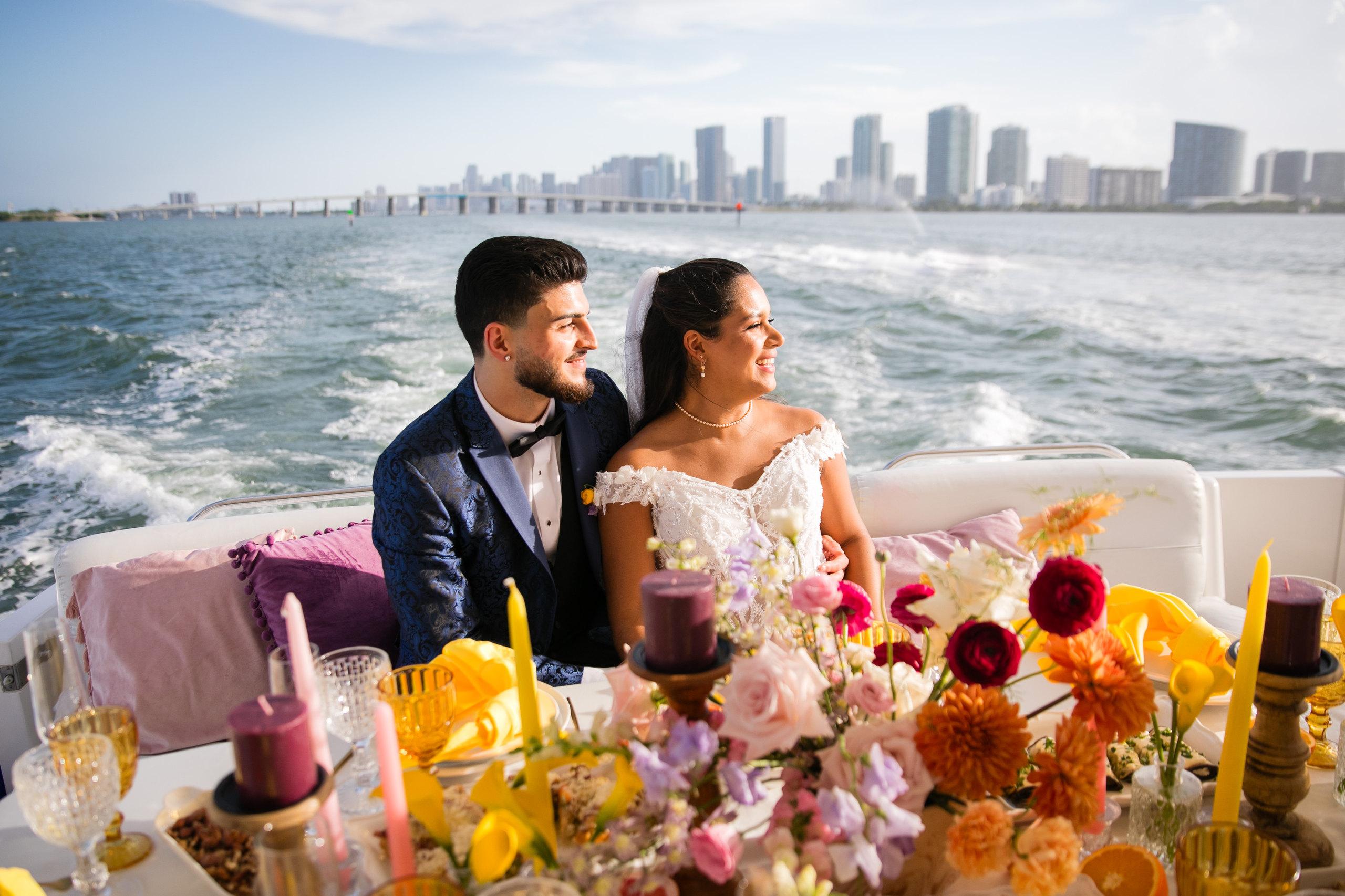 A couple at a floral dinner on a yacht deck at dusk